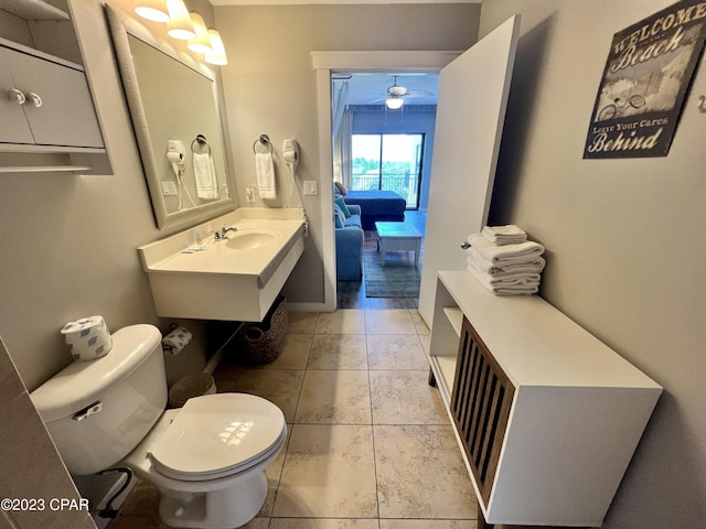 bathroom featuring toilet, a ceiling fan, a sink, ensuite bath, and baseboards