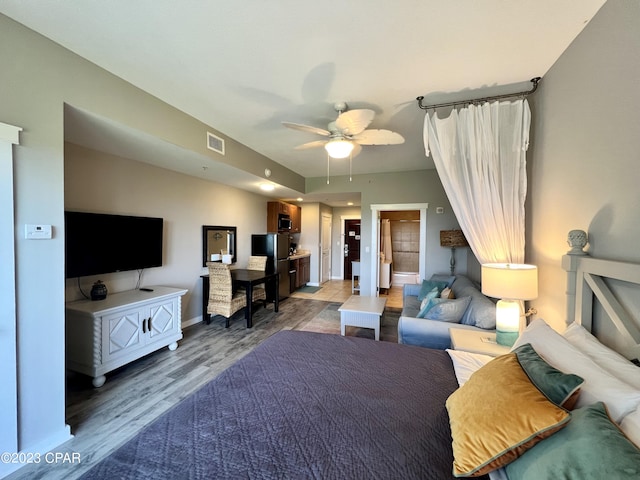 bedroom with light wood-style flooring, visible vents, ceiling fan, and baseboards