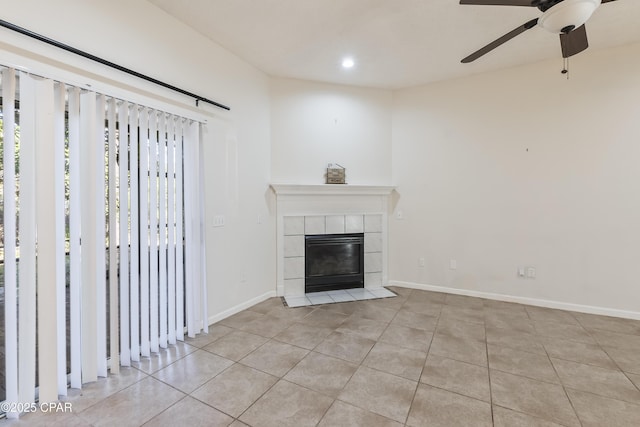 unfurnished living room with tile patterned floors, a ceiling fan, a tile fireplace, and baseboards