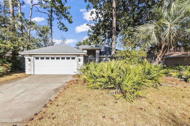 single story home featuring roof with shingles, an attached garage, driveway, and stucco siding