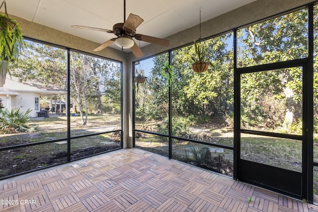 unfurnished sunroom with ceiling fan