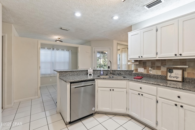 kitchen featuring a peninsula, white cabinets, visible vents, dishwasher, and a sink