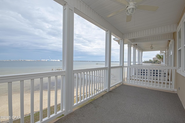 exterior space with a water view, ceiling fan, and a view of the beach