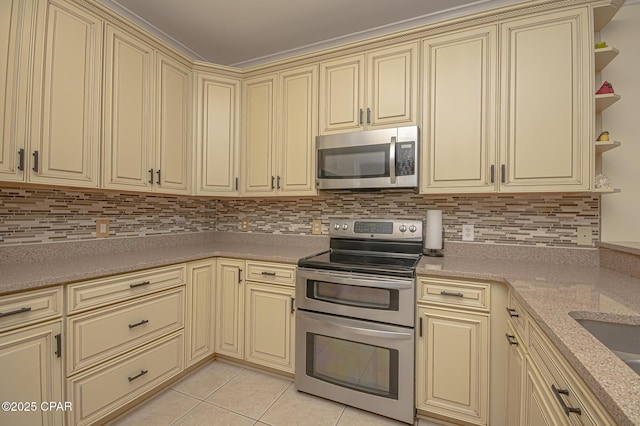 kitchen featuring stainless steel appliances, cream cabinets, and light tile patterned floors