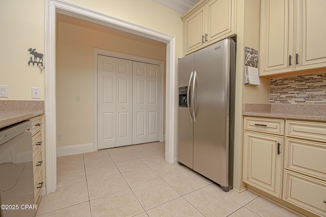 kitchen featuring light tile patterned floors, dishwasher, backsplash, cream cabinets, and stainless steel fridge with ice dispenser