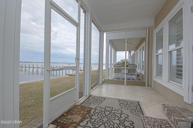 unfurnished sunroom featuring a water view