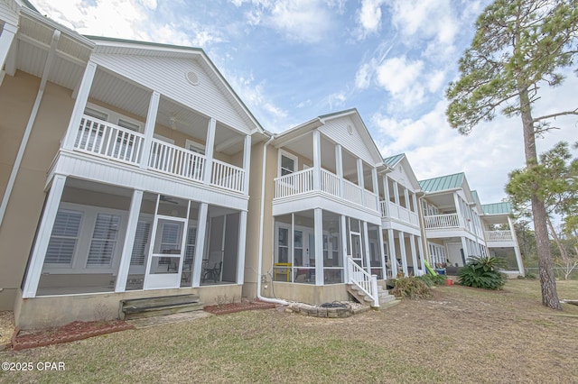 view of side of home with a yard and a sunroom