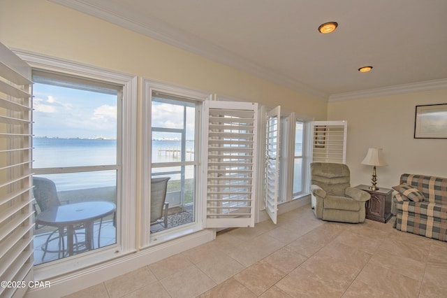 sitting room with a water view, ornamental molding, and light tile patterned floors