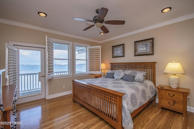 bedroom featuring ornamental molding, a water view, access to outside, and light wood-type flooring