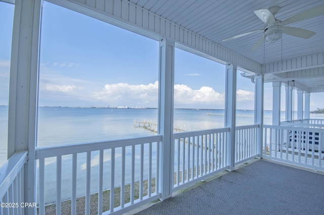 unfurnished sunroom featuring a water view, a healthy amount of sunlight, and ceiling fan