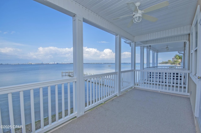 unfurnished sunroom featuring a water view and ceiling fan