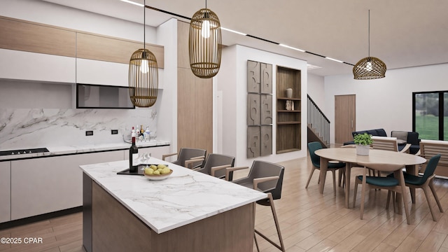 kitchen with hanging light fixtures, light hardwood / wood-style floors, and white cabinets