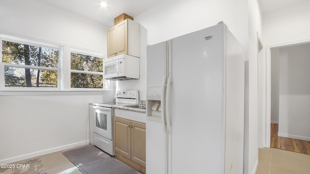 kitchen featuring white appliances, light tile patterned flooring, and baseboards