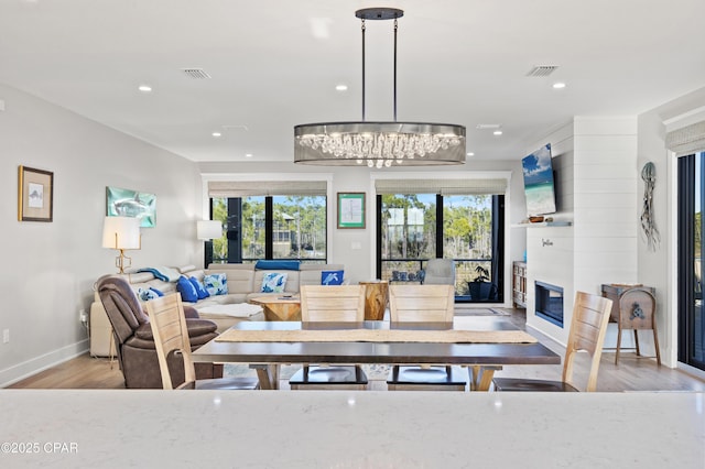 dining space with a fireplace and light hardwood / wood-style flooring