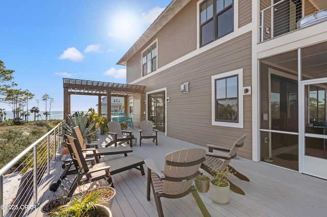 deck featuring a water view, a sunroom, and a pergola