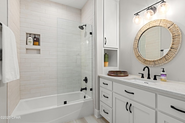 bathroom with tiled shower / bath and vanity