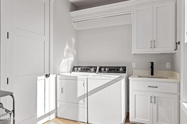 laundry room with sink, washer and clothes dryer, and cabinets