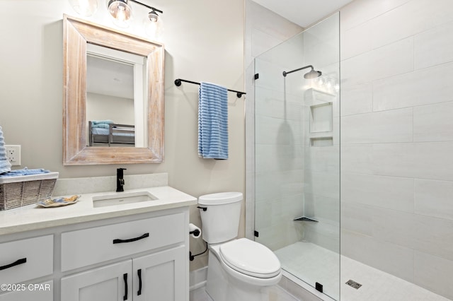 bathroom featuring vanity, a shower with door, and toilet