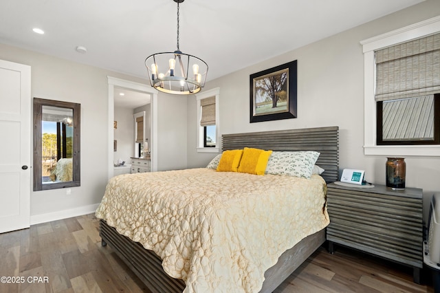 bedroom featuring dark hardwood / wood-style flooring, multiple windows, and a chandelier