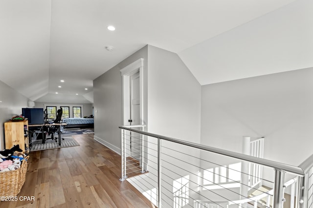 hall featuring lofted ceiling and hardwood / wood-style flooring