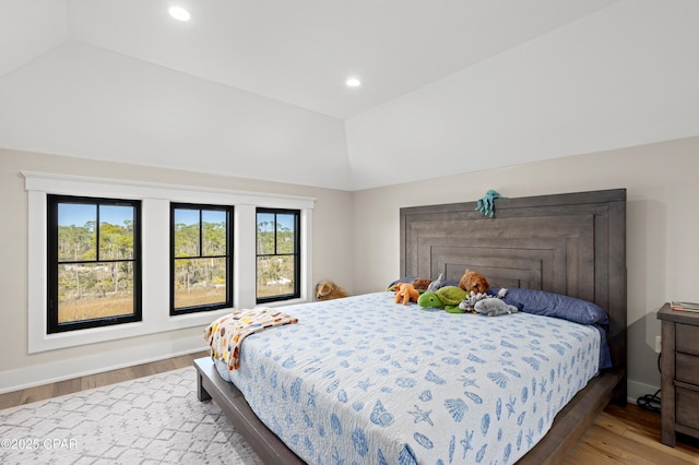 bedroom with wood-type flooring and vaulted ceiling