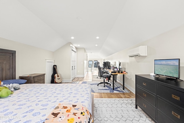 bedroom featuring light hardwood / wood-style flooring, vaulted ceiling, and an AC wall unit