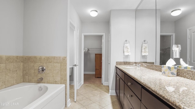 bathroom with vanity, a washtub, and tile patterned floors