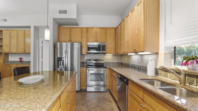 kitchen featuring pendant lighting, tasteful backsplash, sink, light stone counters, and stainless steel appliances