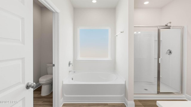 bathroom featuring wood-type flooring, toilet, and independent shower and bath