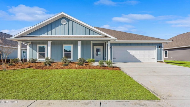 view of front of house with a garage, a front lawn, and covered porch