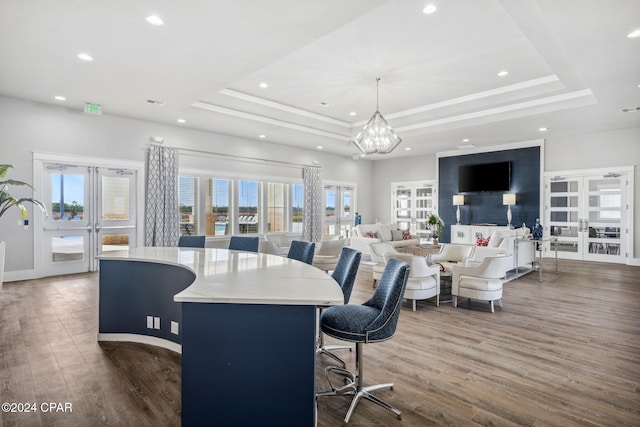 dining space with french doors, dark hardwood / wood-style flooring, and a raised ceiling