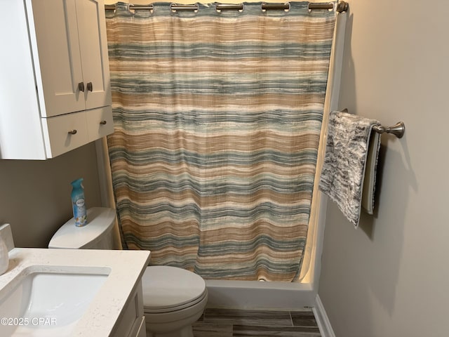 bathroom with hardwood / wood-style flooring, vanity, toilet, and curtained shower