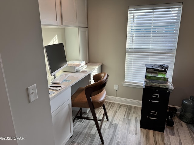 office area with built in desk and light hardwood / wood-style floors