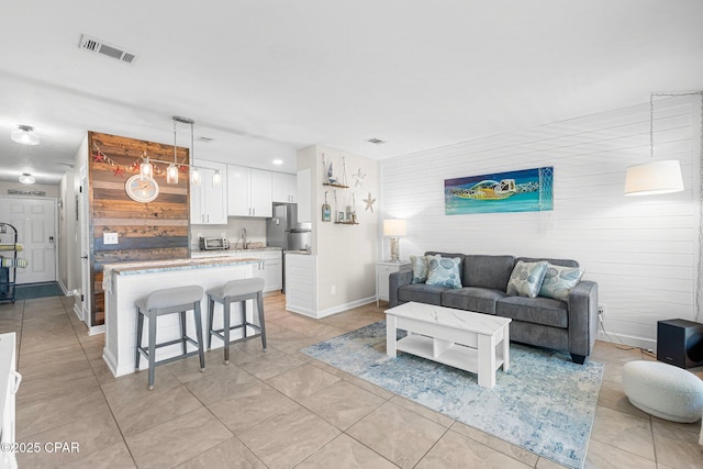 living room featuring sink and light tile patterned floors