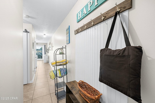 corridor featuring a barn door and light tile patterned floors