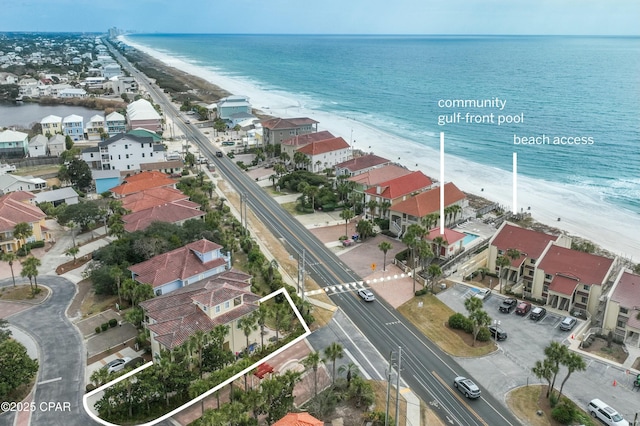 drone / aerial view with a view of the beach, a water view, and a residential view