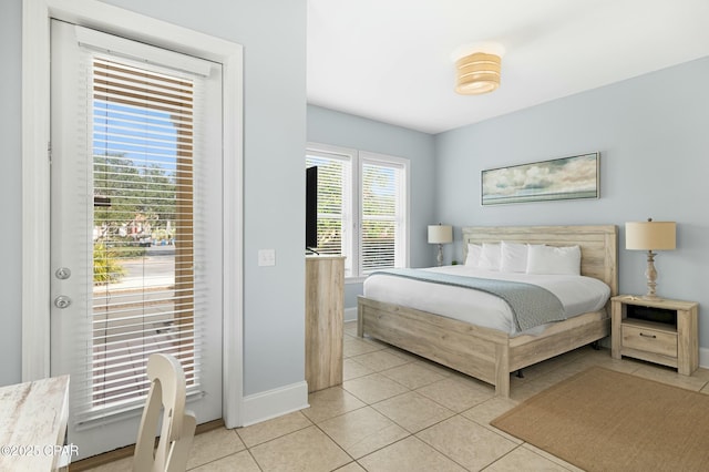 bedroom with light tile patterned floors, multiple windows, and baseboards