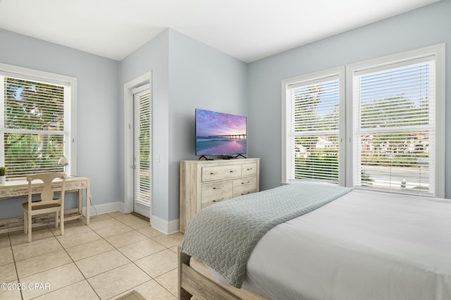 bedroom featuring light tile patterned floors, access to outside, multiple windows, and baseboards