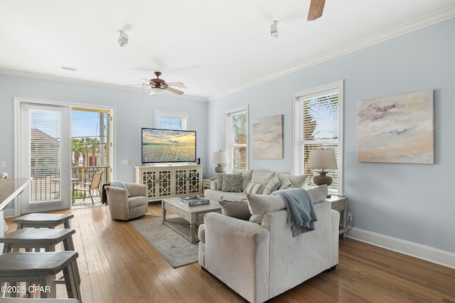 living room with plenty of natural light, ornamental molding, a ceiling fan, and wood finished floors