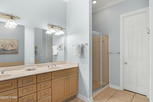 bathroom with double vanity, a stall shower, a sink, tile patterned flooring, and baseboards