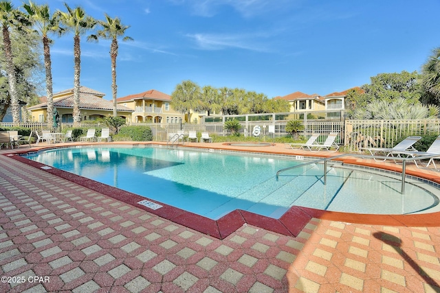 community pool featuring a residential view and fence