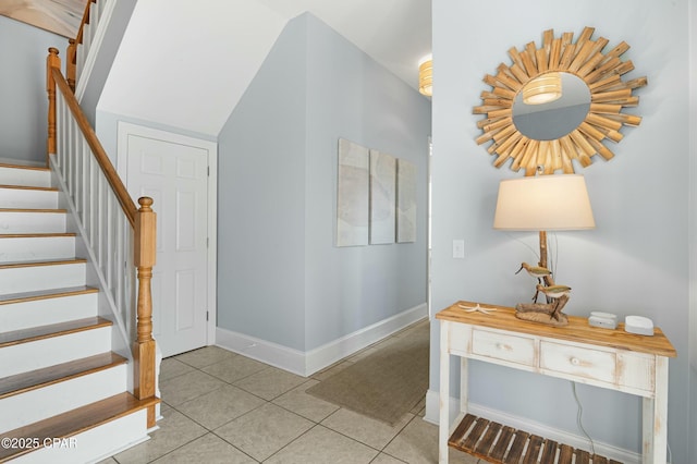 interior space featuring light tile patterned floors, baseboards, and stairway