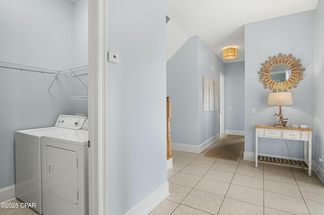 clothes washing area featuring laundry area, light tile patterned flooring, independent washer and dryer, and baseboards