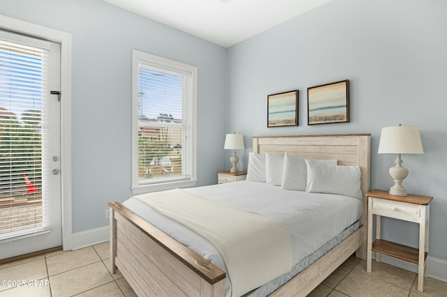 bedroom featuring light tile patterned floors, access to outside, and baseboards