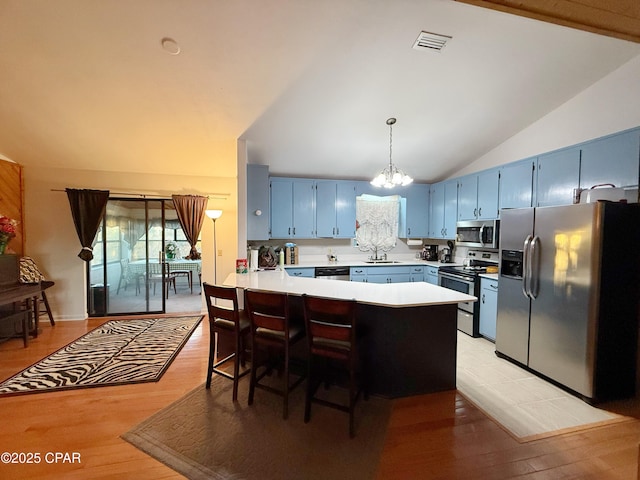 kitchen with visible vents, blue cabinetry, light countertops, appliances with stainless steel finishes, and a peninsula