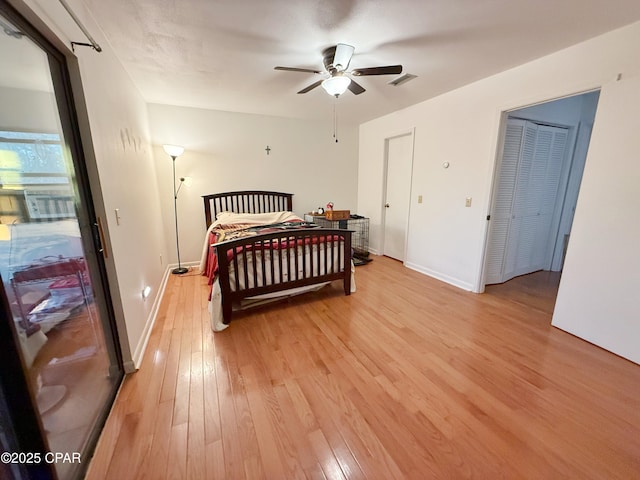 bedroom featuring visible vents, baseboards, light wood-style flooring, and a ceiling fan