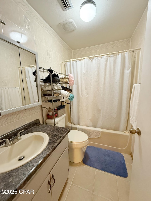 full bathroom with vanity, visible vents, tile patterned flooring, tile walls, and shower / tub combo with curtain