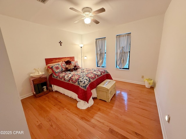 bedroom featuring baseboards, ceiling fan, and light wood finished floors