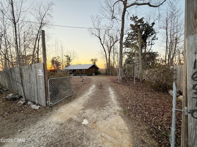 view of road with a gated entry, dirt driveway, and a gate