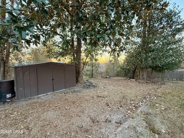 view of yard with fence, an outdoor structure, and a shed